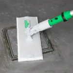 Pad abrasif blanc Unger OPS20 utilisé avec un porte-pad pour éliminer les saletés tenaces