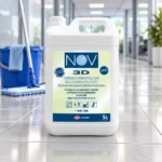 Bidon NOV 3D Pamplemousse 5 L sur un sol carrelé, près d’un seau et d’un balai de lavage.